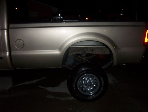 2000 Ford F-450 - Rear side view of a 2000 Ford F-450 pickup truck, showing the wheel well and bed.