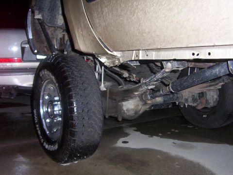 2000 Ford F-450 - A close-up view of a truck's rear wheel, suspension, and drivetrain components.