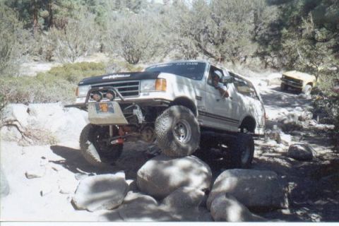 1990 Ford Bronco - Modified 1990 Ford Bronco tackling a challenging rocky obstacle on an off-road excursion.