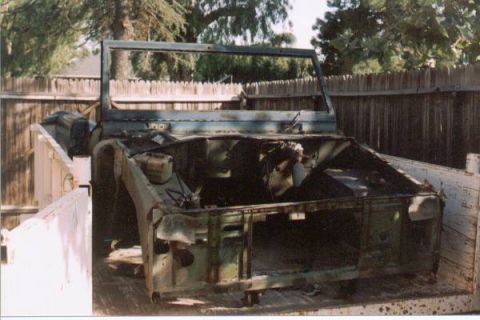 1966 Ford Bronco - The body of a 1966 Ford Bronco is seen in a truck bed, showing significant rust and missing components.