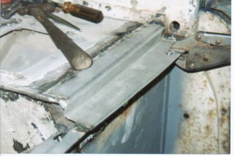 1966 Ford Bronco - Tools are present for metal repair on a vehicle's body panel.