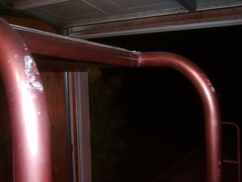 1978 Ford Bronco - Close-up of a red roll bar, possibly from a vintage vehicle.