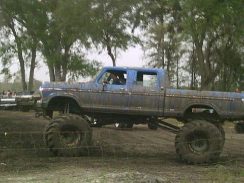 1993 Ford Bronco - This lifted pickup truck is covered in mud, suggesting it has been used for off-roading.