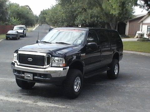 2003 Ford Excursion - A black Ford Excursion SUV is parked on a residential street with other vehicles in the background.