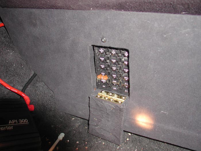 Car's fuse box with several fuses visible, some with orange tint. Also shows part of an API 300 inverter