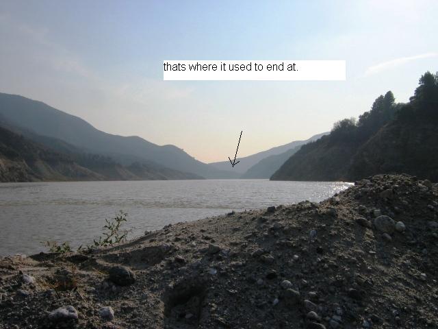 Hazy reservoir between hills with arrow and text 'thats where it used to end at.'