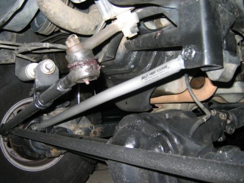 1985 Ford Bronco - Close-up of a vehicle's steering and suspension system, showing various metal components and a branded steering stabilizer.