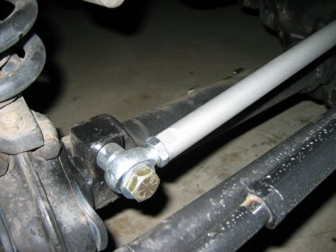 1985 Ford Bronco - This image shows a close-up view of a vehicle's steering linkage components, including a tie rod end and a bolt.