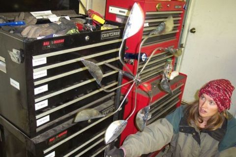 1990 Ford Bronco - A woman observes a homemade wind spinner positioned in front of stacked tool chests.