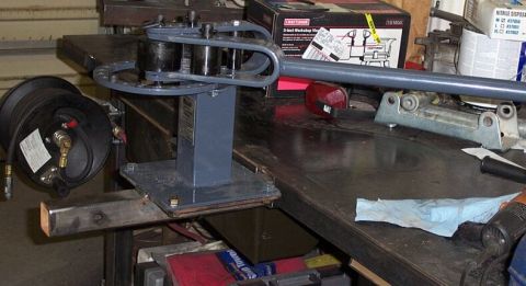 1990 Ford Bronco - Workbench setup with a tube bender and air hose reel, plus a Craftsman box in the background.