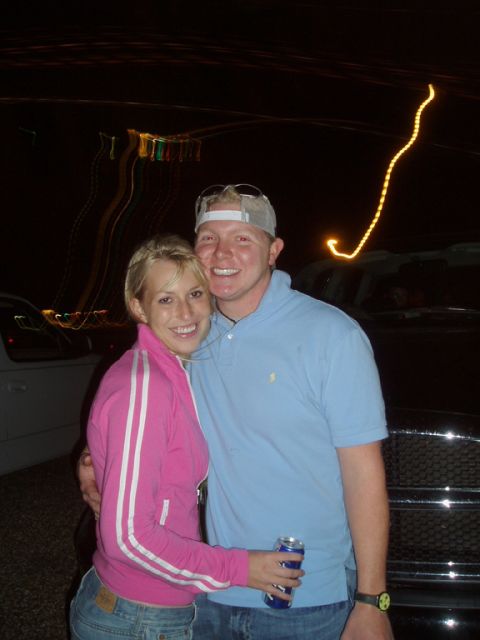 1990 Ford Bronco - A young couple poses at night in front of a dark-colored vehicle, with a lighter-colored vehicle visible in the background at left. The veh…