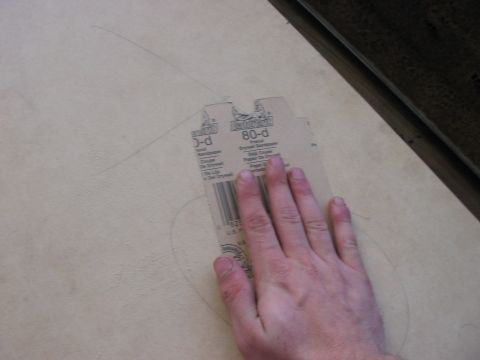 1988 Ford Bronco - A hand is shown holding a piece of sandpaper with "80-d" printed on it over a surface marked with pencil lines.