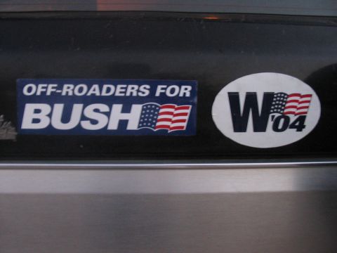 1988 Ford Bronco - Political bumper stickers reading 'OFF-ROADERS FOR BUSH' and 'W '04' are affixed to a dark surface.