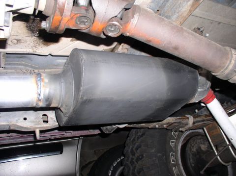 1990 Ford Bronco - Underside view of a vehicle's exhaust system, showing the muffler and driveshaft components.