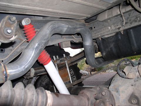 1990 Ford Bronco - Close-up of exhaust system and suspension parts on a vehicle.