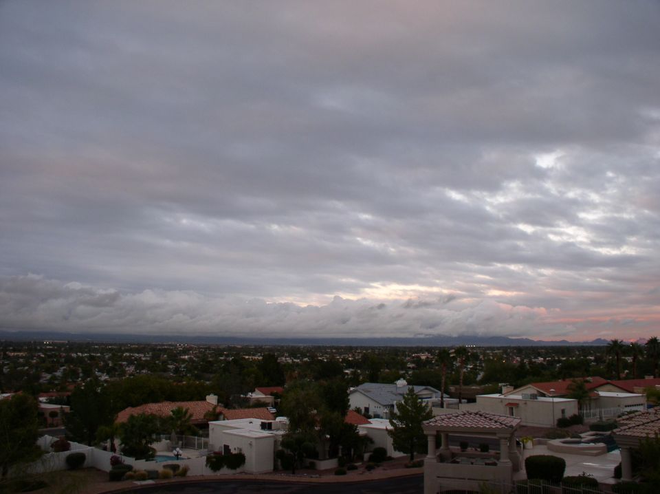 Overcast sky above suburban houses and distant mountains