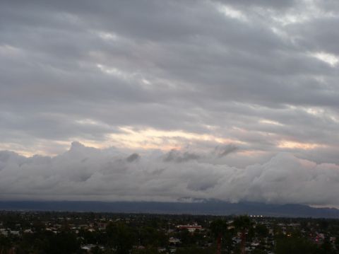 1990 Ford Bronco - A dramatic sky filled with heavy clouds looms over a distant city skyline.