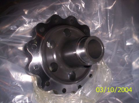 1983 Ford Bronco - Close-up of a new bare-steel differential carrier case still in its oiled plastic packaging, showing the ring-gear bolt flange, machined be…