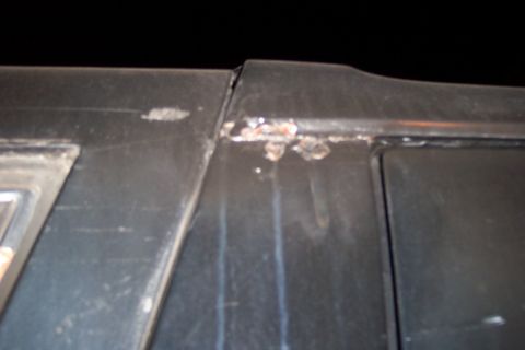 1986 Ford Bronco - Close-up of a rusted seam on the black roof of a vehicle, showing signs of wear.