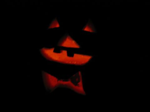 1985 Ford LTD Crown Victoria - A jack-o'-lantern with a carved face and bow tie glows in the dark.