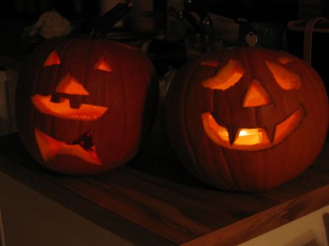 1985 Ford LTD Crown Victoria - Two carved jack-o'-lanterns sit on a wooden surface, illuminated by candles inside.