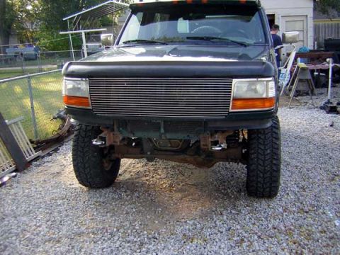 1995 Ford Bronco - This 1992 Ford F-Series truck shows its front end, a prominent chrome grille and large off-road tires.