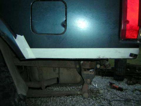 1995 Ford Bronco - Close-up view of the rear quarter panel, frame, and exhaust system of a vehicle.