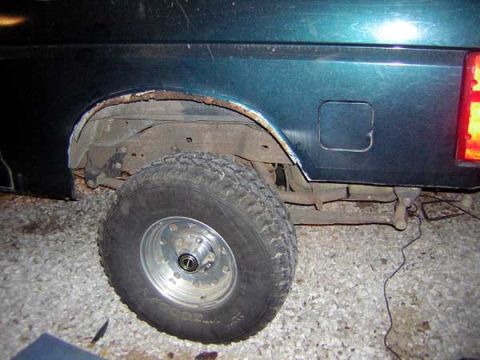 1995 Ford Bronco - Rear side view of a 1995 Ford Bronco, focusing on the wheel well and tire.