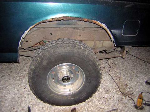 1995 Ford Bronco - The wheel well of a vehicle shows extensive rust damage, indicating a need for repair.
