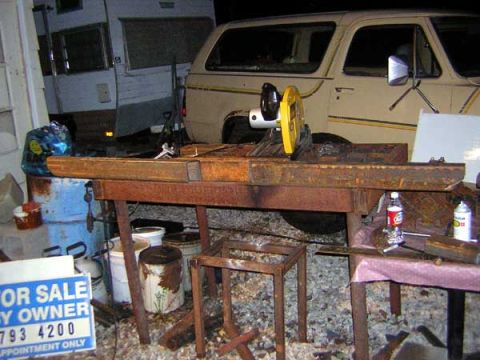 1995 Ford Bronco - A tan 1980s Ford Bronco is parked next to a trailer, with a metal cutting saw in the foreground.