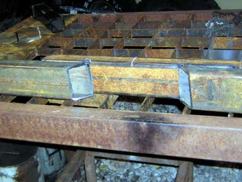 1995 Ford Bronco - Close-up of cut metal pipes on a rusty grid, likely part of a fabrication or repair project.