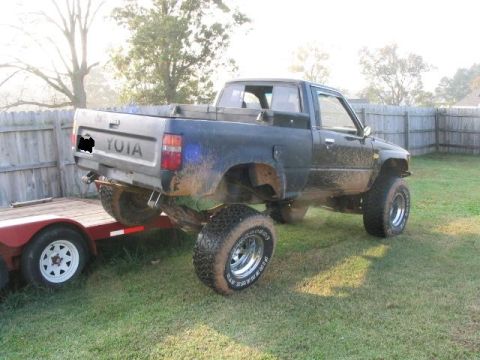 1986 Ford F-150 - Modified Toyota pickup truck, likely from the mid-1980s, is loaded onto a trailer.