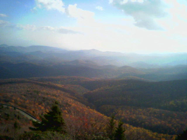 mountain range with autumn trees and a road winding through the hills