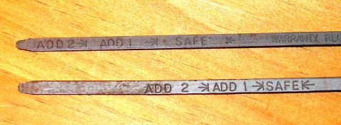 1969 Ford Fairlane - Close-up of two oil dipsticks showing different fill level indicators.