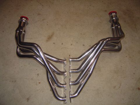 1978 Ford Bronco - A matched pair of polished stainless V8 long-tube headers laid mirror-image on a concrete floor, with four equal-length primaries per side,…