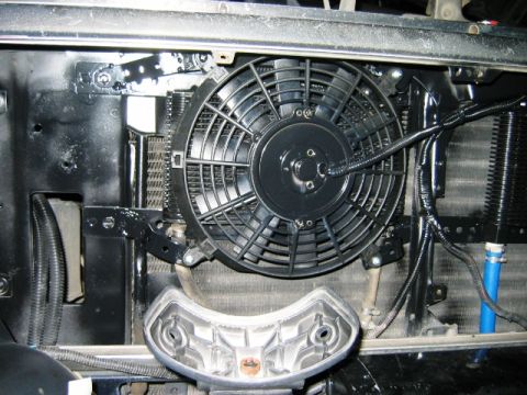 1985 Ford Bronco - Close-up of an aftermarket electric radiator fan assembly installed on a vehicle's front end.