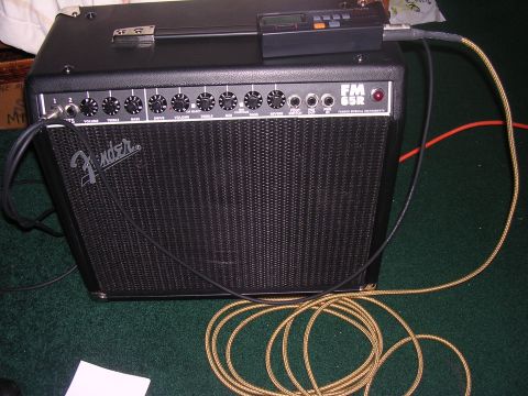 1985 Ford Bronco - A Fender FM 65R guitar amplifier is shown with cables connected and a digital tuner on top.
