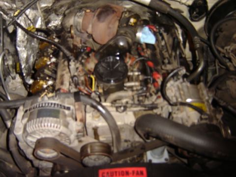 1992 Ford Bronco - Close-up of an engine bay, a turbocharger and other mechanical components.