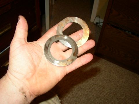 1995 Ford Bronco - A hand displays two used metal rings, possibly automotive parts, against a blurred indoor backdrop.