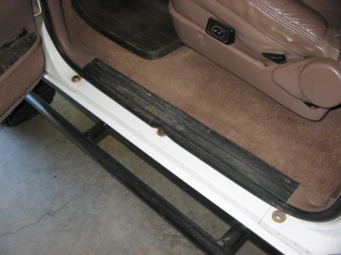 1995 Ford Bronco - Aftermarket rock sliders installed on the interior door sill of a white SUV.