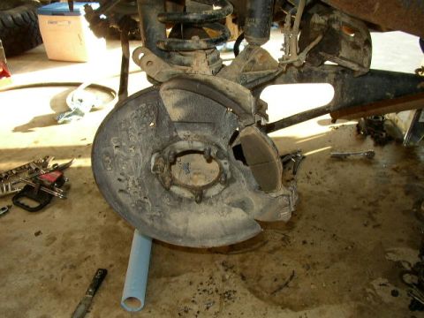 1995 Ford Bronco - Front brake assembly with rotor and caliper removed from vehicle for service.