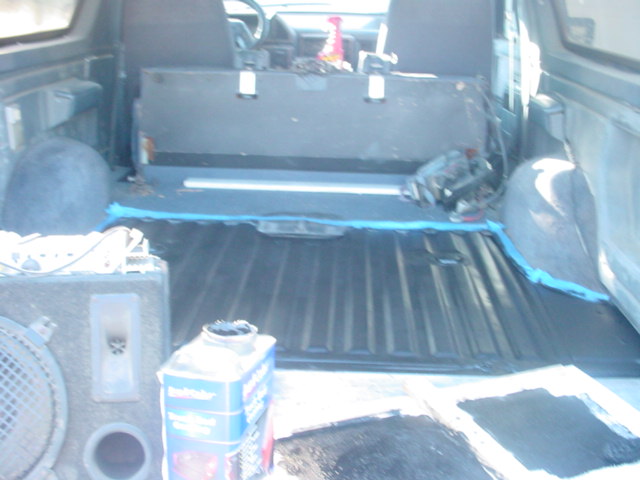 1988 Ford Bronco interior showing bedliner, speaker box, and a bottle of cleaner