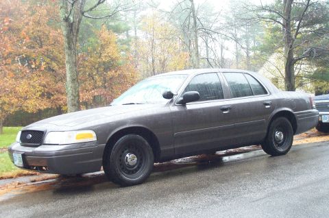 1991 Ford Crown Victoria LTD - Side view of a gray Ford Crown Victoria parked on a wet road during autumn.