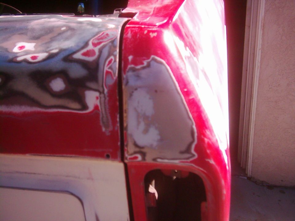 Red vehicle body with visible body filler and primer