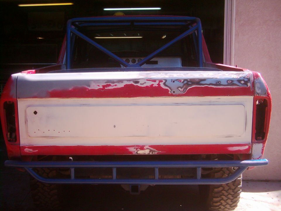 1978 Ford Bronco rear, red and white body with primer, blue roll cage, aftermarket bumper