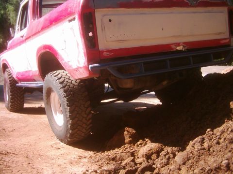 1978 Ford Bronco - This red and white pickup truck appears to be from the 1970s, with a custom bumper and large off-road tires.