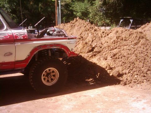 1978 Ford Bronco - This 1978 Ford Bronco is shown with its hood open, positioned next to a large pile of dirt.