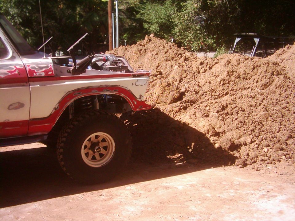 1978 Ford Bronco front quarter view, hood open, next to dirt pile