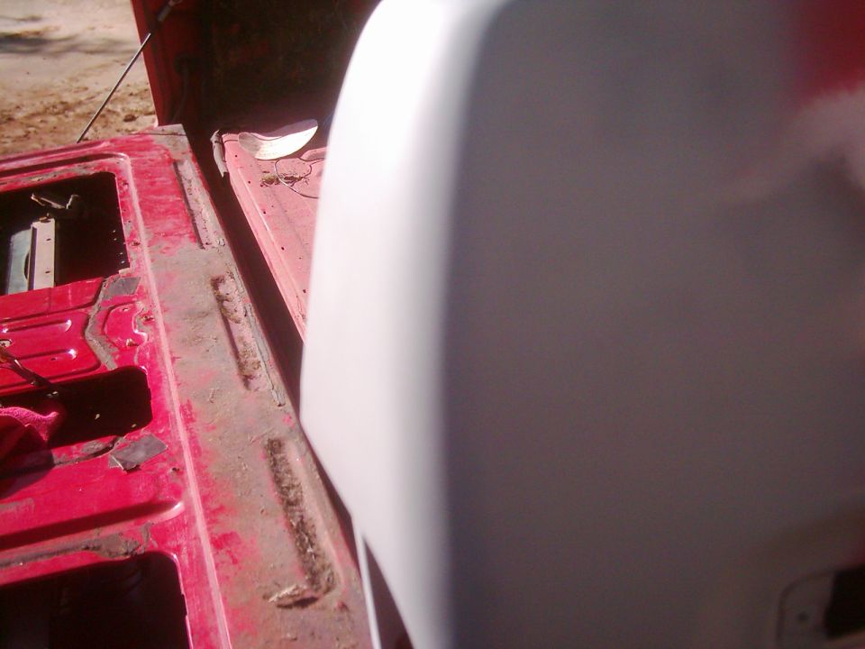 close-up of red truck bed and white tailgate
