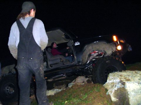 1993 Ford Bronco - A modified SUV navigates rough terrain at night, with occupants visible inside.